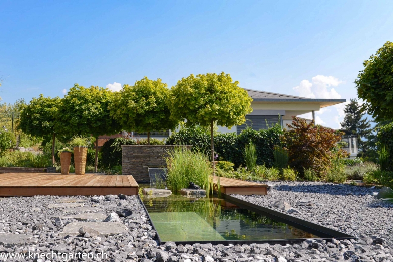 Terrassengestaltung mit Holzdeck, Wasserfall, Becken und Steingarten