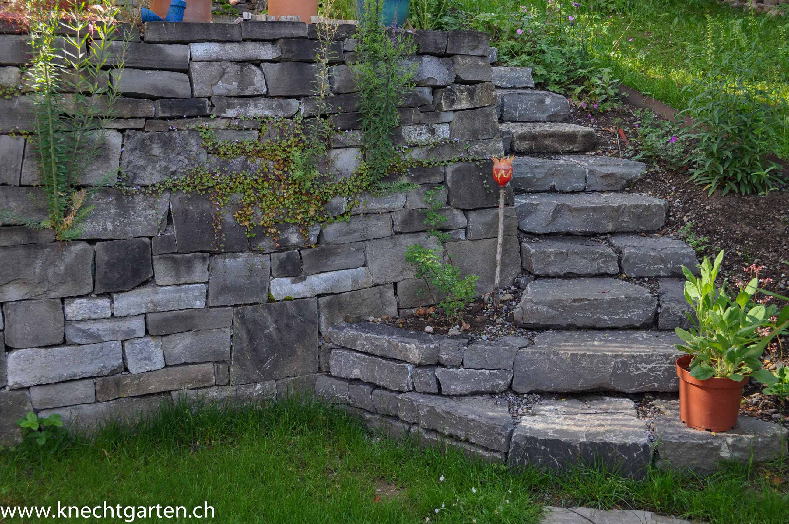 Rustikale Natursteintreppe mit Kurve aus grauem Kalkstein