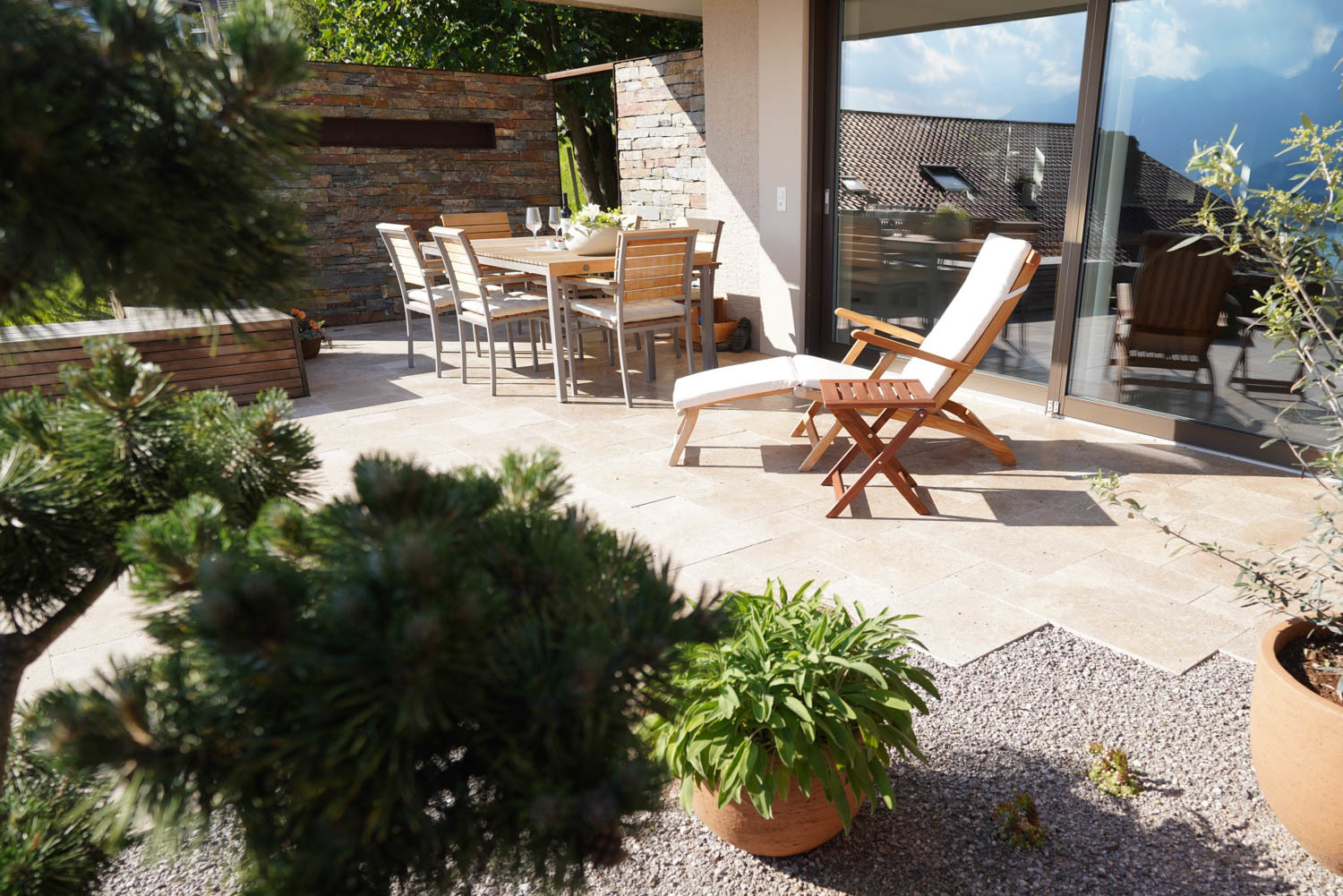 Terrassensitzplatz mit Natursteinbelag und Natursteinmauern