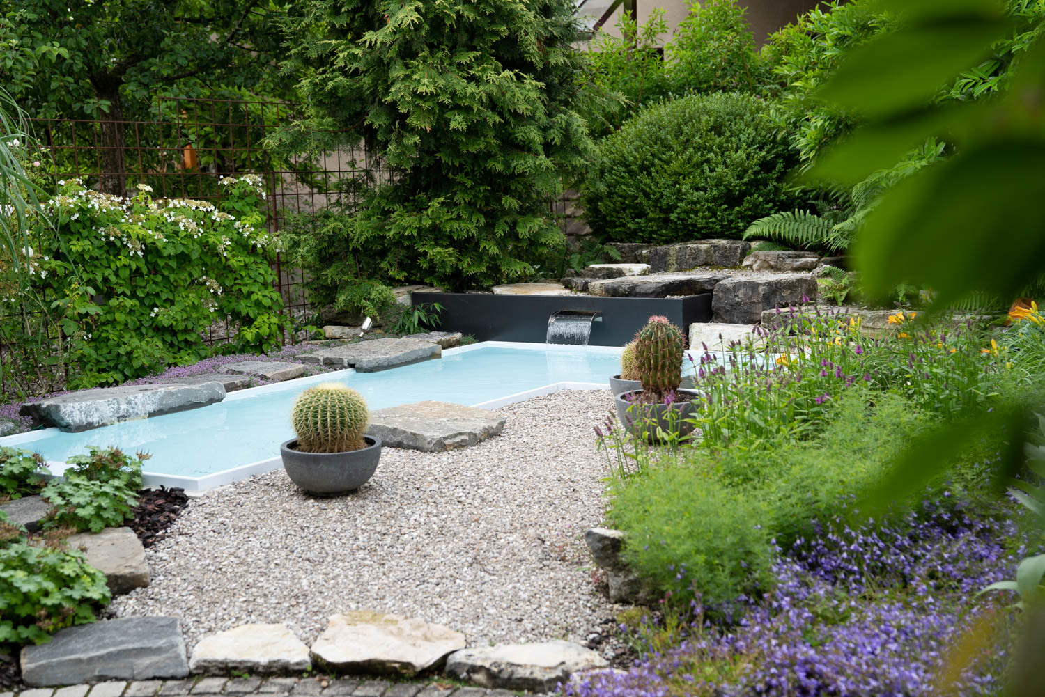 Wassergarten mit Eckpool, Wasserfall und Natursteinen