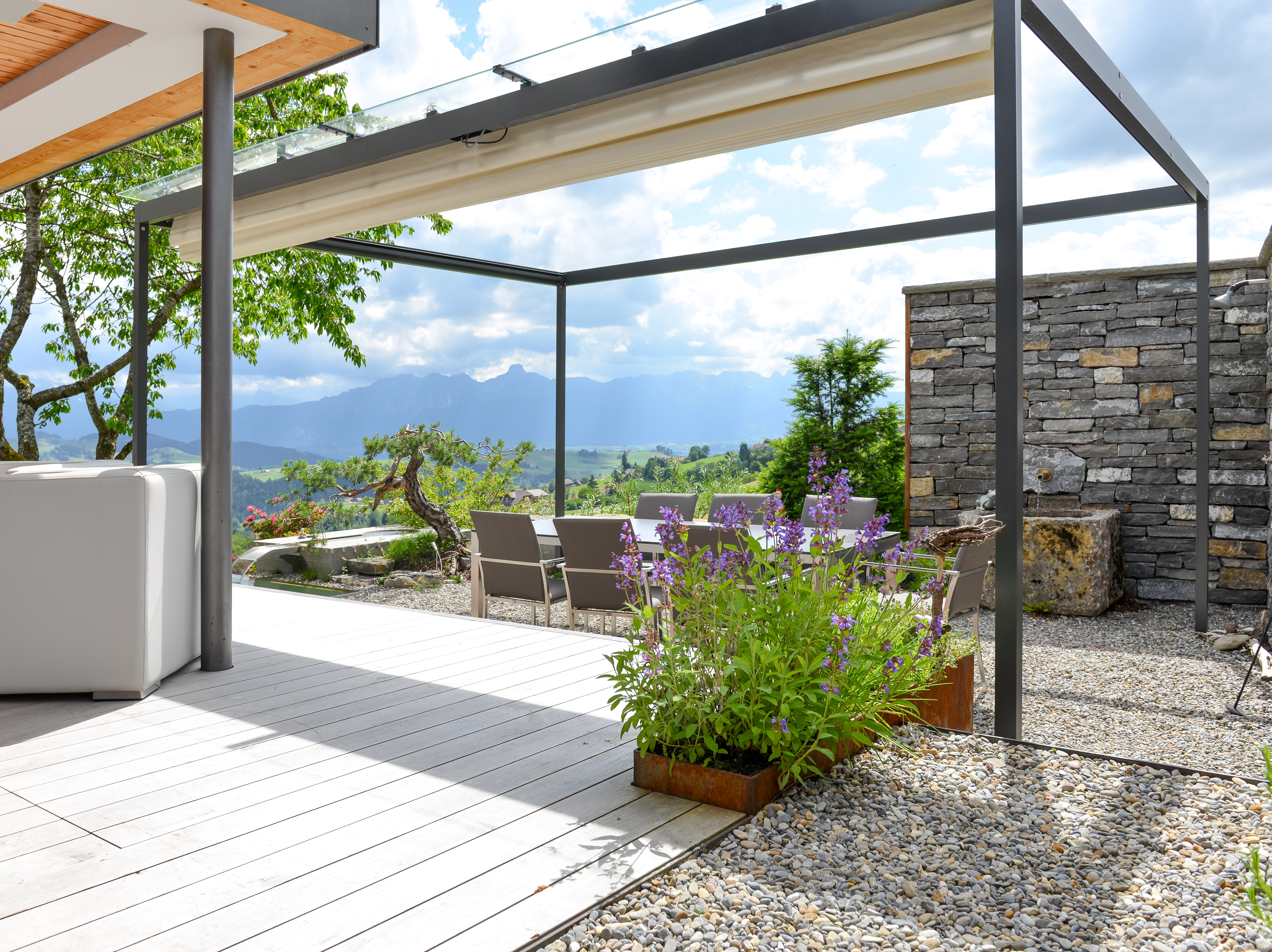 Terrassengestaltung mit Holzdeck, Badebrunnen und Naturstein