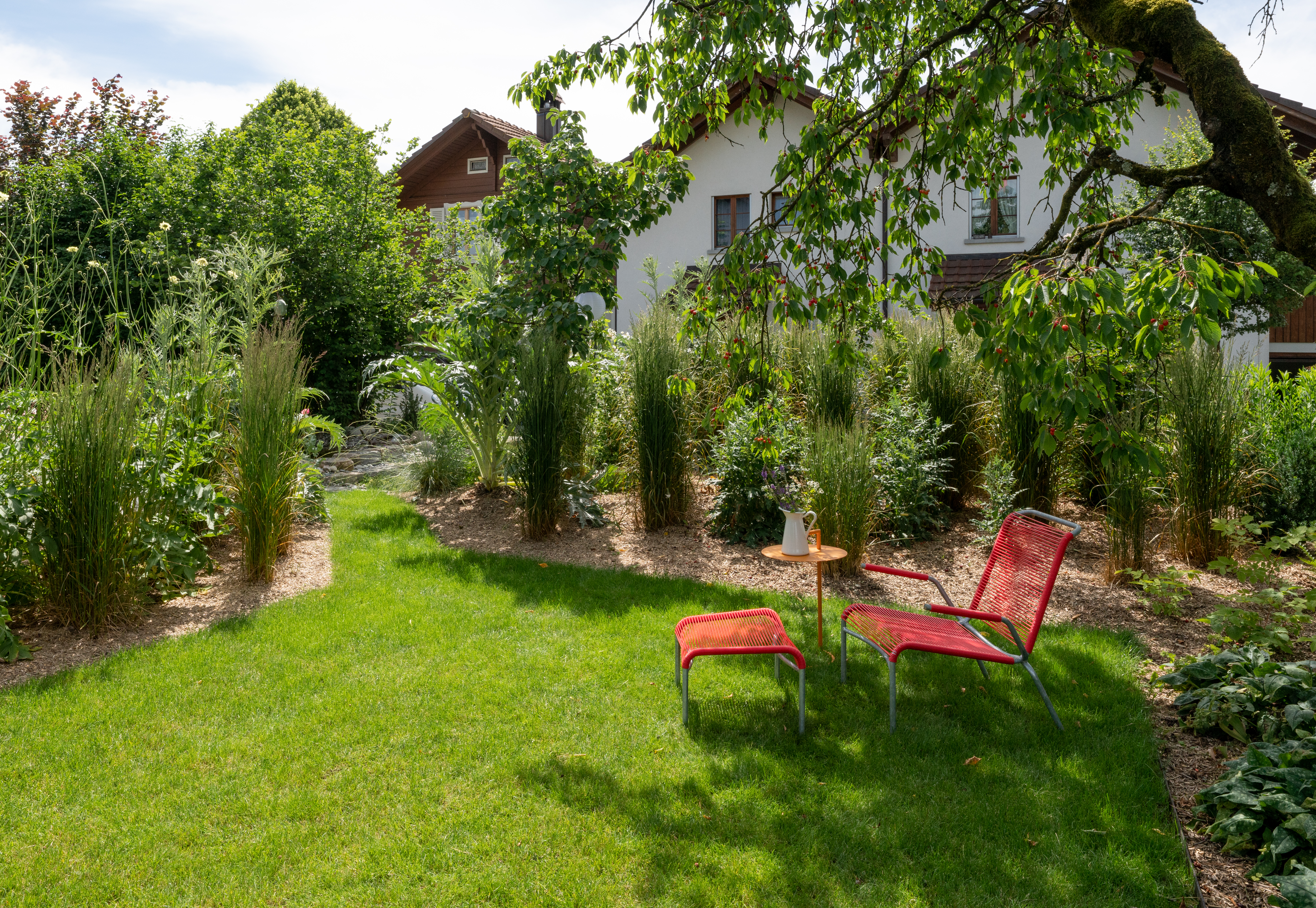 hohe Gräser spenden mehr Geborgenheit für das Sitzplätzchen unter dem Kirschbaum
