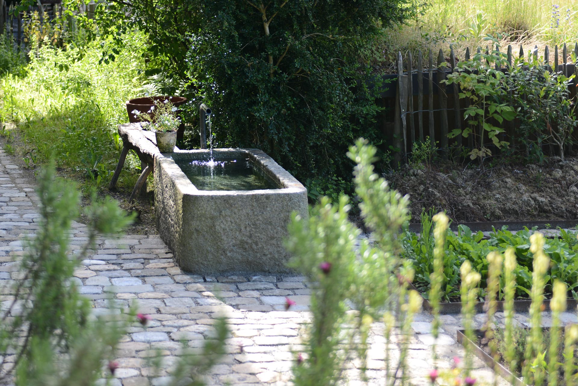 Plätschernder Brunnen inmitten eines idyllischen Gartens