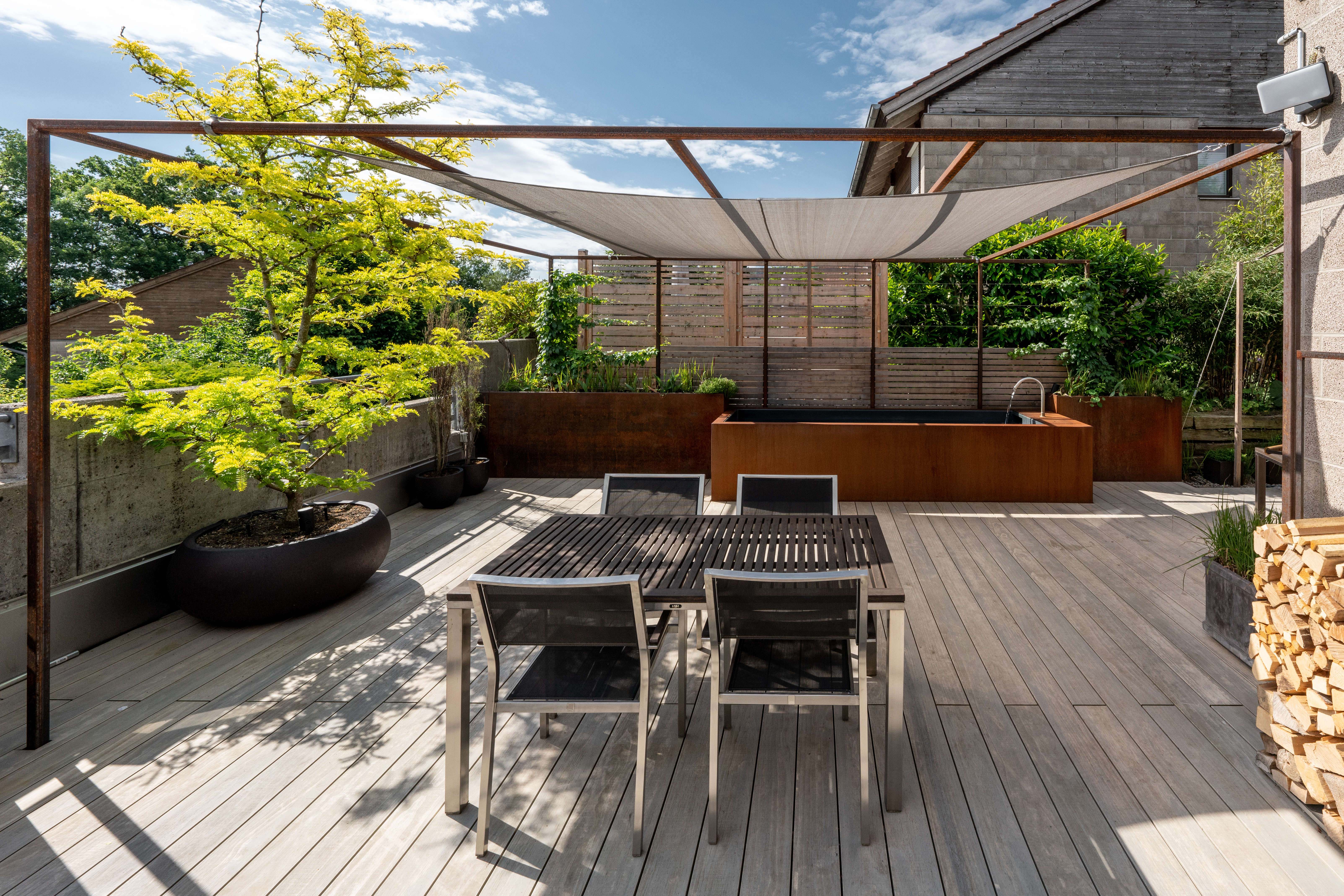 Auf einer sonnigen Terrasse lädt ein Badebrunnen zur Abkühlung ein.