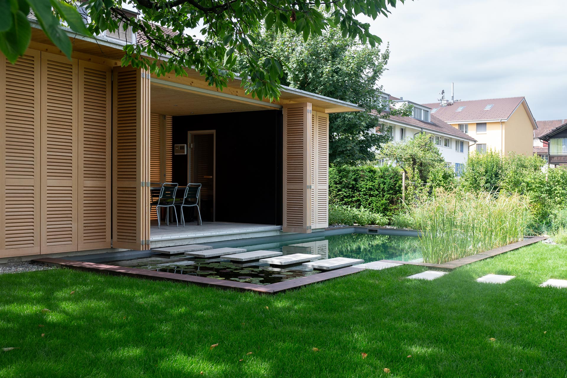 Vor der Aussensauna lockt ein klarer Naturpool zur Abkühlung.